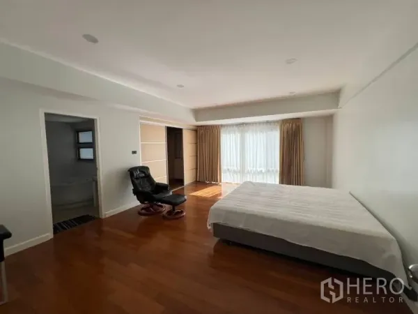 联排别墅 出租在Khlong Toei, Bangkok - 主卧空间宽敞，木地板、大窗户，配套独立卫浴。