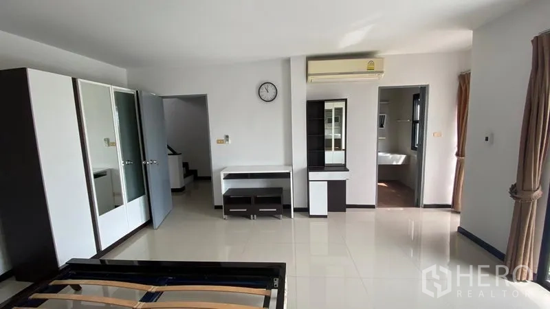 Townhouse for rent in Bang Na, Bangkok - Spacious bedroom with wardrobes, air conditioner, desk and access to an ensuite.