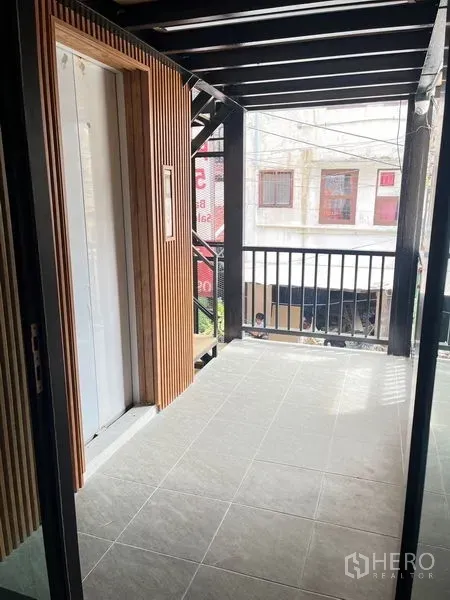 Retail Space for rent - Small covered balcony with metal railing and external staircase overlooking the street.