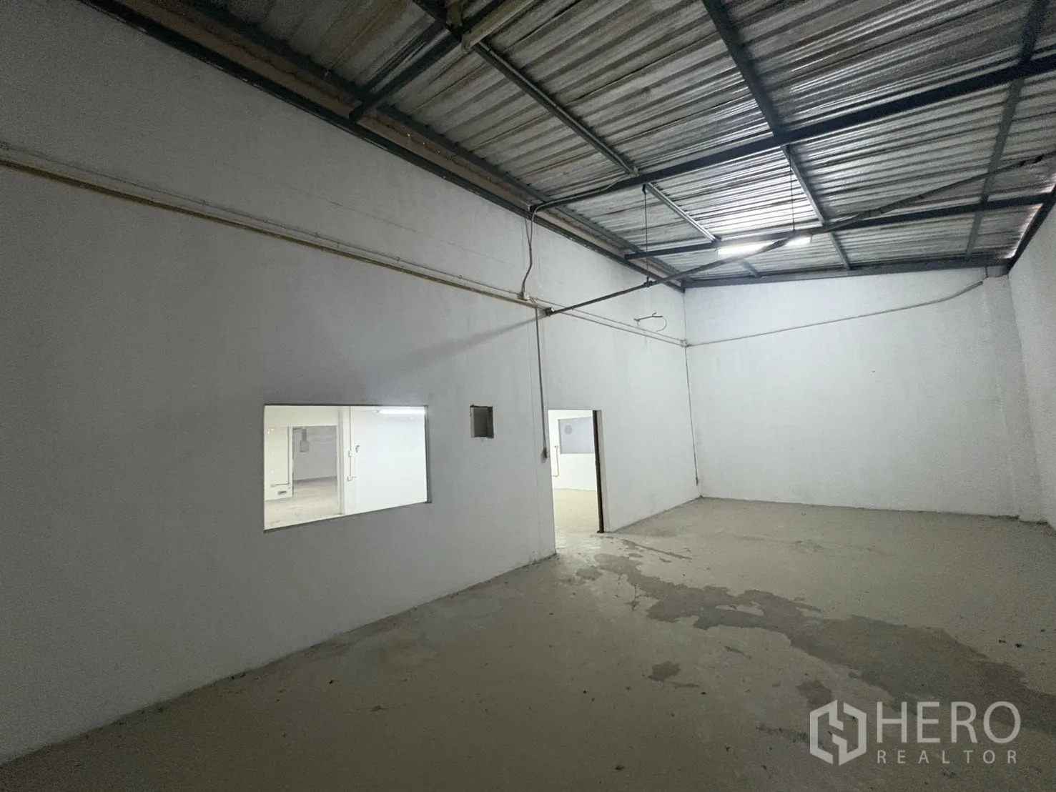 Warehouse for rent in Bang Phli, Samut Prakan - Second mezzanine room with interior window and concrete floor.