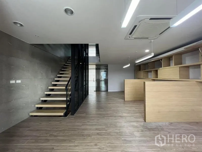 Home Office for rent in Bueng Kum, Bangkok - Open office floor with staircase and long run of built-in shelving.