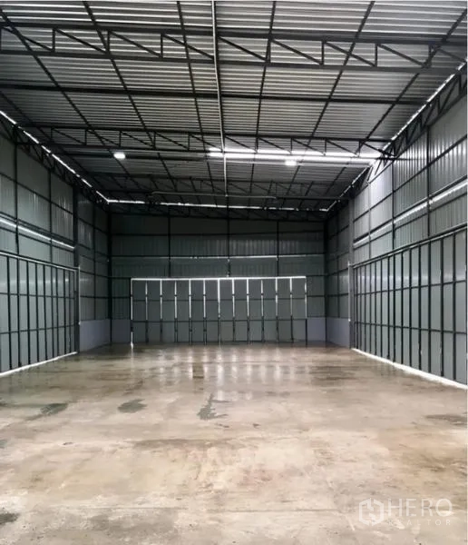 Warehouse for rent in Khlong Sam Wa, Bangkok - Spacious high-ceiling warehouse interior with metal walls, wide sliding door and polished concrete floor.