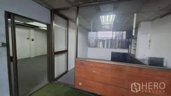 Shophouse for rent in Watthana, Bangkok - Partitioned office area with glass panels and a wood reception counter.