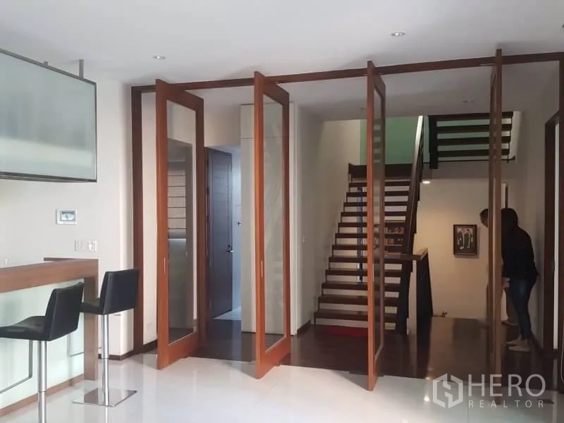 Home Office for rent or sale in Bang Rak, Bangkok - Entrance hall with folding glass-panel wooden doors, breakfast bar and staircase.