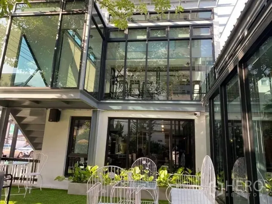 Retail Space for rent in Suan Luang, Bangkok - Modern two-story glass-front building with a courtyard lawn and outdoor seating in Suan Luang.