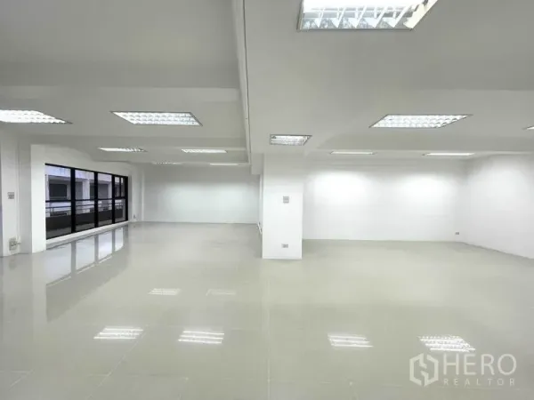 Office Space for rent in Khlong Toei, Bangkok - Spacious workspace with large windows and glossy tile flooring.