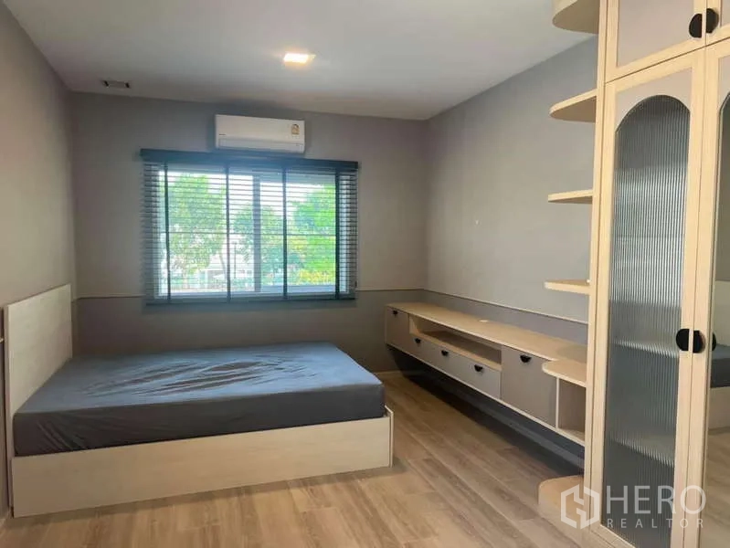 Detached House for rent in Prawet, Bangkok - Bright bedroom with bed, large window and built-in storage.
