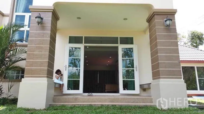 Detached House for rent or sale in Pak Kret, Nonthaburi - Covered front porch with double glass doors, tiled steps and a small lawn.