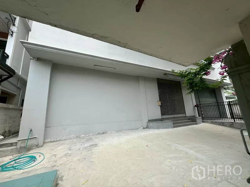 Warehouse for rent in Phra Khanong, Bangkok - Concrete loading driveway leading to roller shutter and entry steps at the warehouse