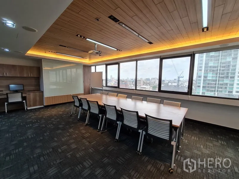 Office Space for rent in Bang Rak, Bangkok - Conference room with panoramic windows, city views, and built-in cabinetry beneath feature lighting.