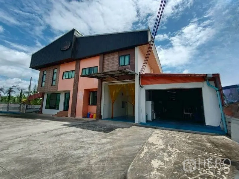 工厂 for rent or sale in Krathum Baen, Samut Sakhon - 两层工厂建筑外观，设宽阔车道与有顶卸货区。