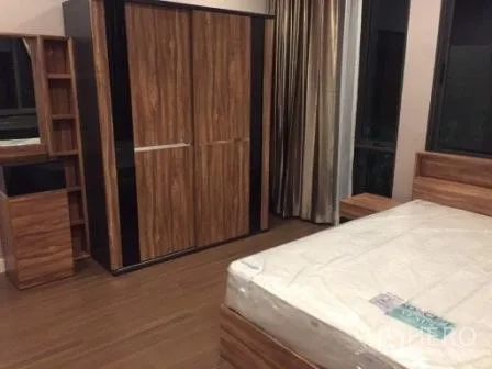Detached House for rent in Bang Kapi, Bangkok - Secondary bedroom with bed, wooden wardrobe and dressing table on wood flooring.