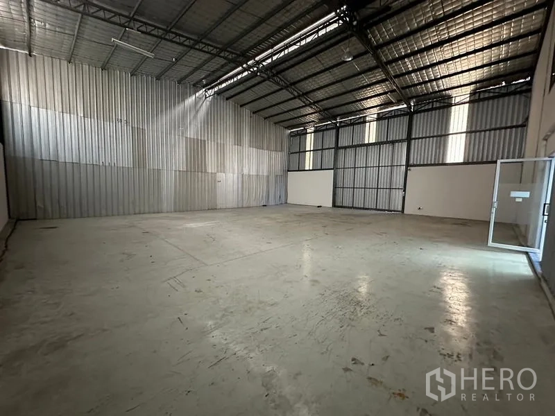 Office Space for rent - Spacious high-ceiling warehouse with metal cladding and skylight strips.