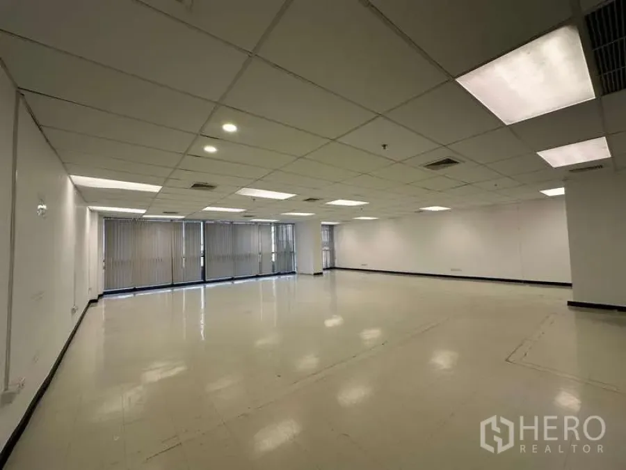 Office Space for rent - Bright office area featuring long window line with vertical blinds, recessed lights and a flexible open layout for workstations.