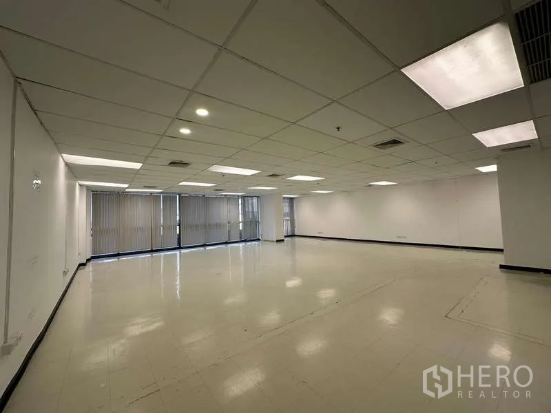 Office Space for rent - Bright office area featuring long window line with vertical blinds, recessed lights and a flexible open layout for workstations.