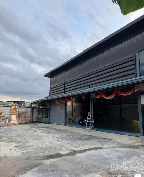 Warehouse for sale in Thanyaburi, Pathum Thani - Steel-clad warehouse with wide roller shutters and a spacious concrete yard in Thanyaburi.