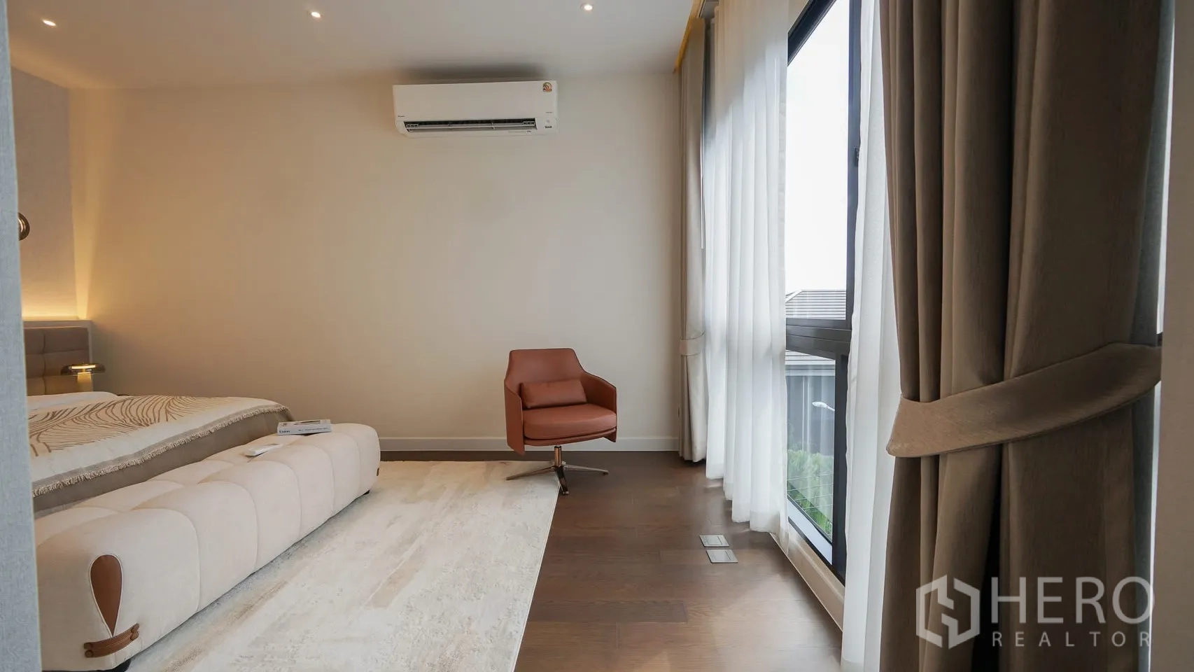 Detached House for rent or sale in Bang Kapi, Bangkok - Guest bedroom with bench at the foot of the bed and ambient lighting.
