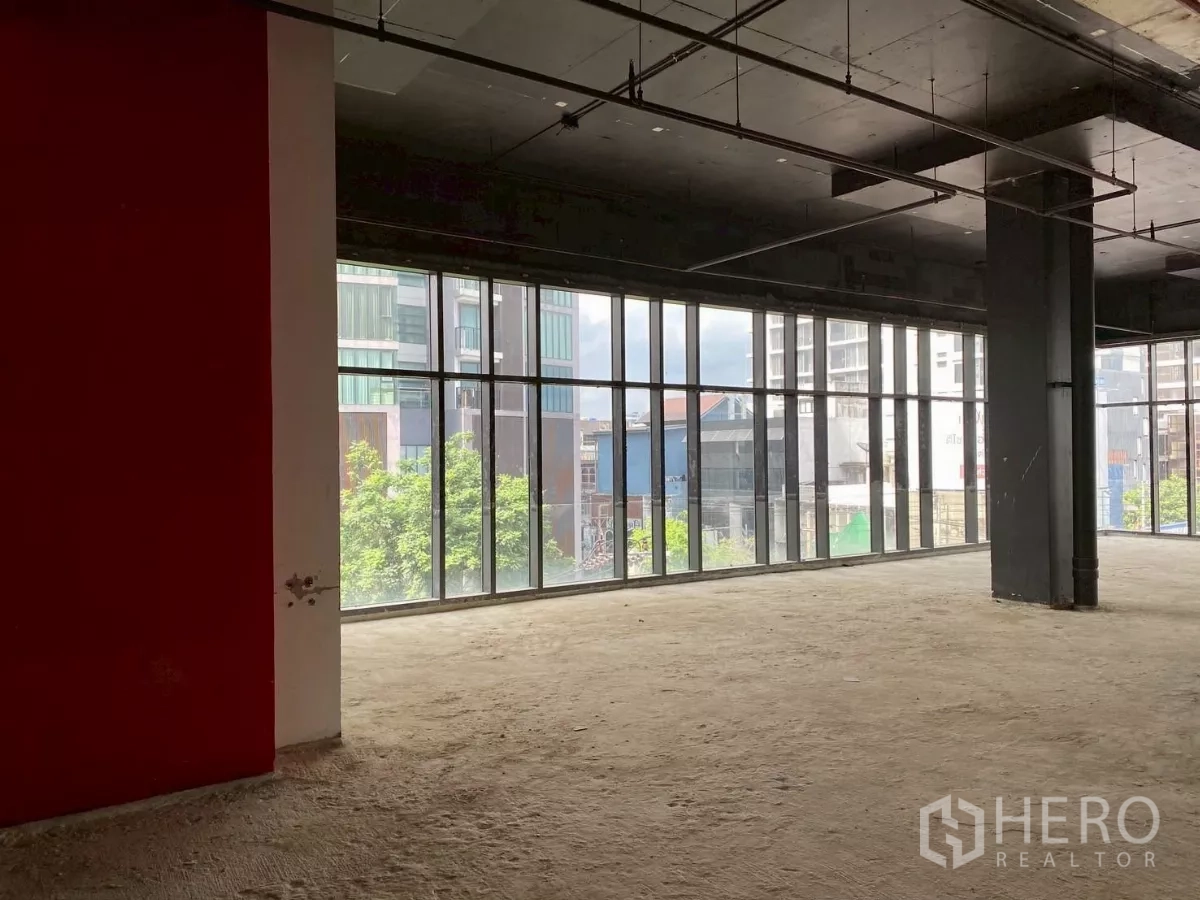 Retail Space for rent - Retail floor with red feature wall and panoramic floor-to-ceiling windows.