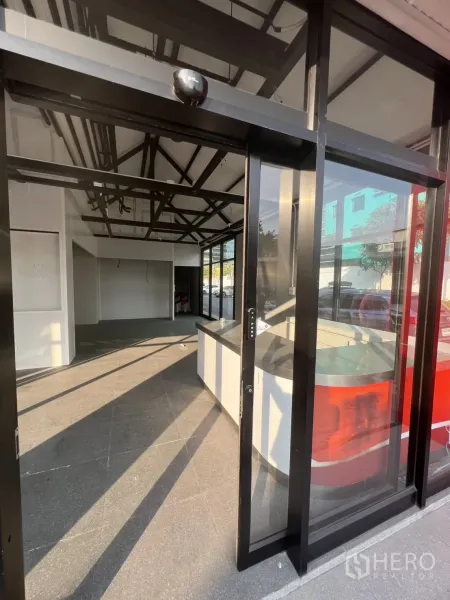 Retail Space for rent - Sliding glass entrance revealing a bright shop space with counter at the front.