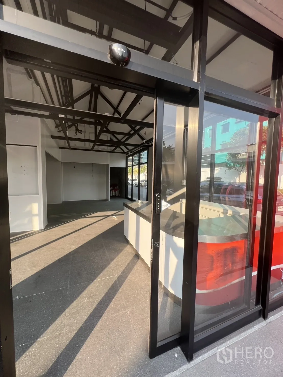 Retail Space for rent - Sliding glass entrance revealing a bright shop space with counter at the front.