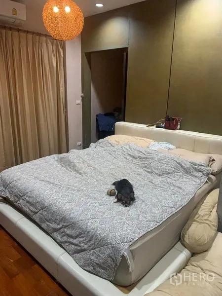 Detached House for rent in Prawet, Bangkok - Master bedroom with large bed, pendant light, and floor-to-ceiling curtains.