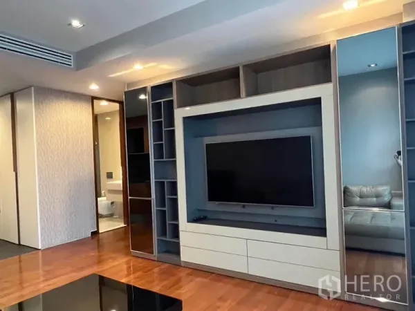 Condominium for rent - Modern built‑in TV wall with shelving and glossy cabinetry in the condo living room.