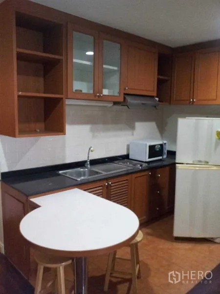 Condominium for rent - Fitted kitchen with cabinets, sink, fridge, microwave and a breakfast bar with stools.