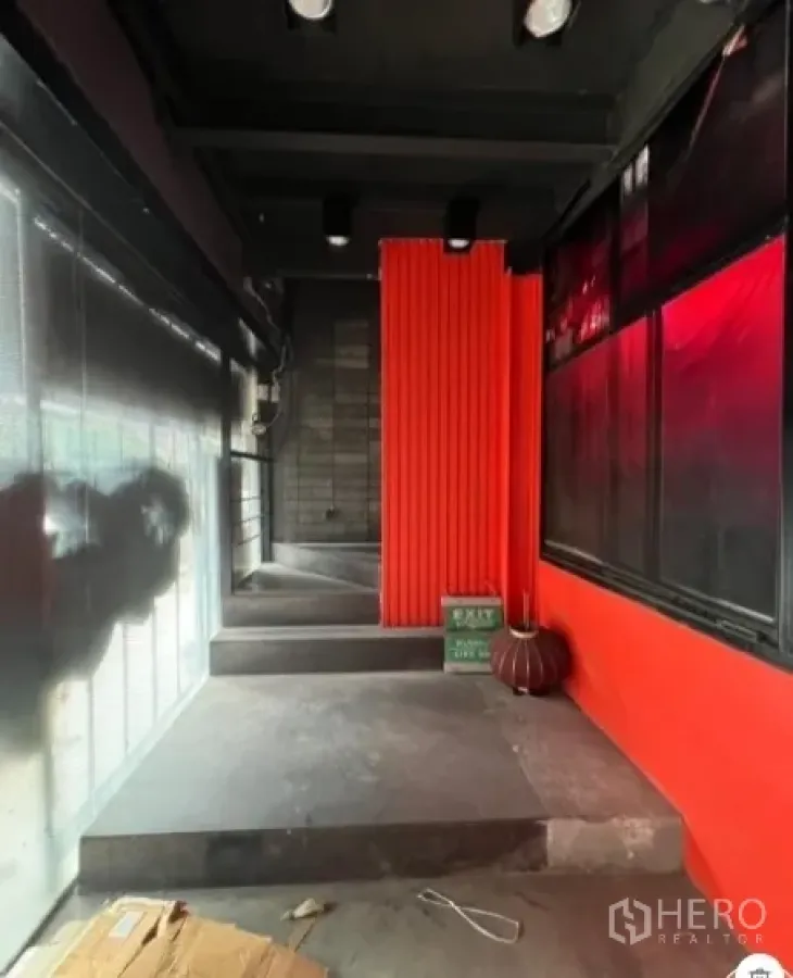 Retail Space for rent in Khlong Toei, Bangkok - Repeating view of corridor showing red feature wall, window panels and stepped floor.