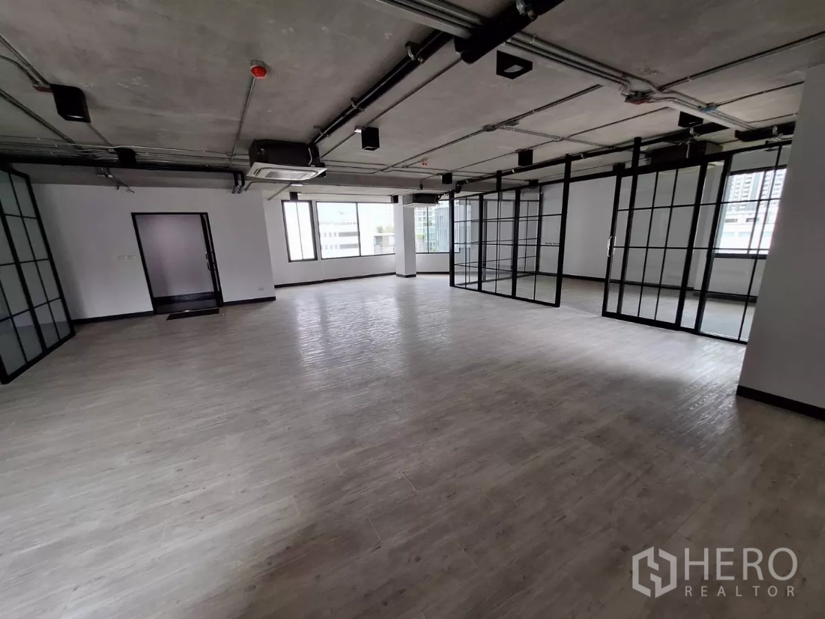 Office Space for rent in Watthana, Bangkok - Large open office featuring multiple sliding glass partitions and wide windows.