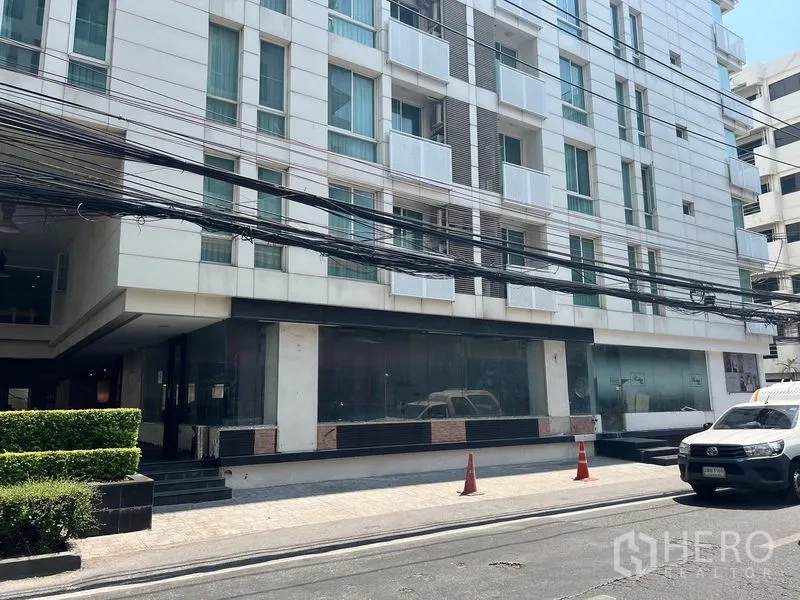 Retail Space for rent in Watthana, Bangkok - Ground-floor retail frontage with wide glass windows beneath a mid-rise in Watthana, Bangkok.
