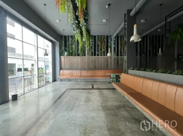 Retail Space for rent - Bright seating zone with floor-to-ceiling windows and long tan bench.