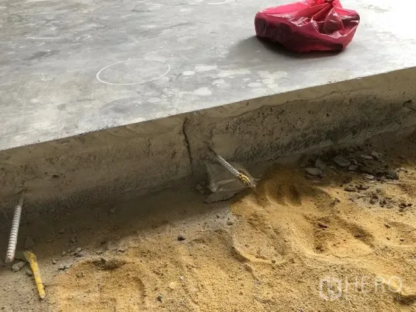 Warehouse for rent or sale in Sai Noi, Nonthaburi - Close-up of a raised concrete slab edge with exposed rebar on a sand base.