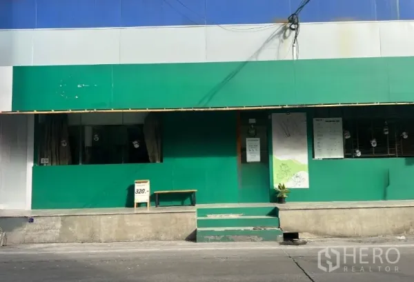 Retail Space for rent in Khlong Toei, Bangkok - Long shopfront with green cladding, display windows and central steps from the sidewalk.