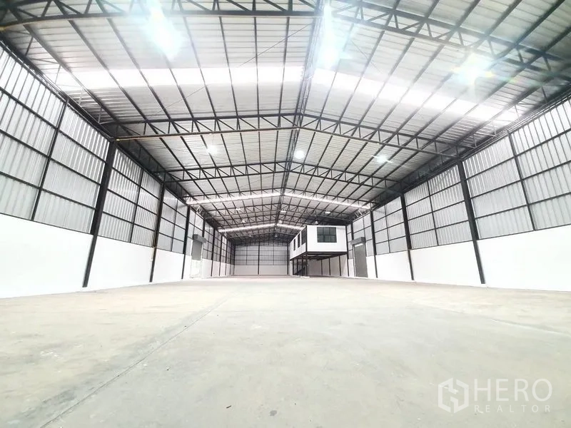 Warehouse for rent in Bang Khen, Bangkok - Open clear-floor warehouse with LED lighting and metal cladding throughout the space.