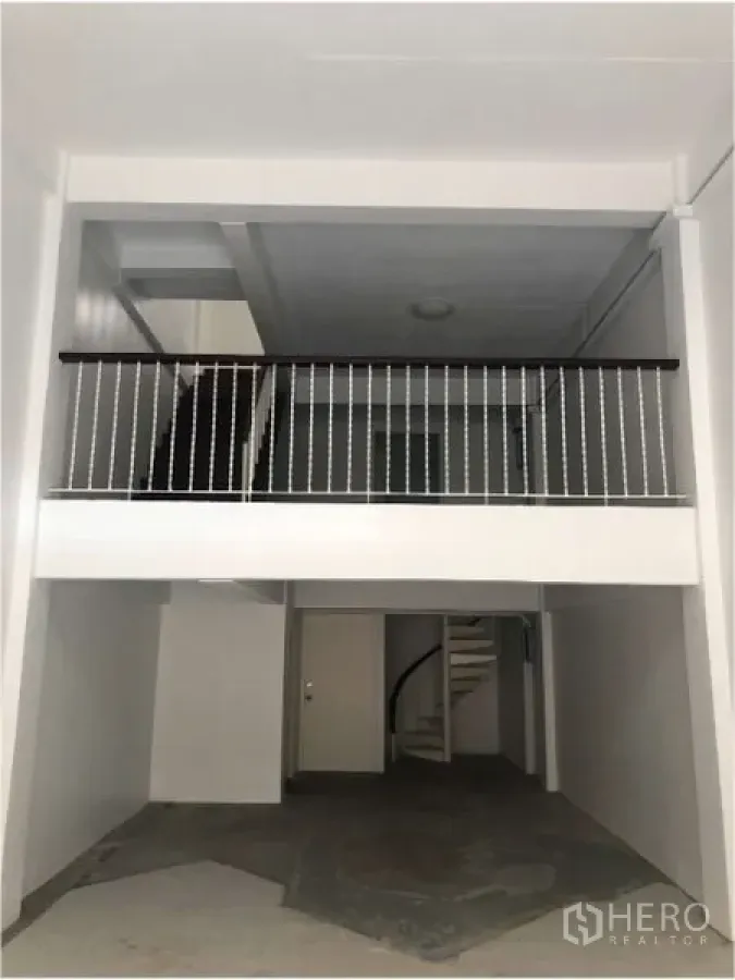 Shophouse for rent in Watthana, Bangkok - Double-height shophouse ground floor with mezzanine and railing, ready for fit-out.