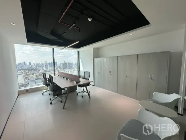 Office Space for rent in Din Daeng, Bangkok - Open office with bench desks, mesh chairs, storage cabinets, and a wide city view through large windows.