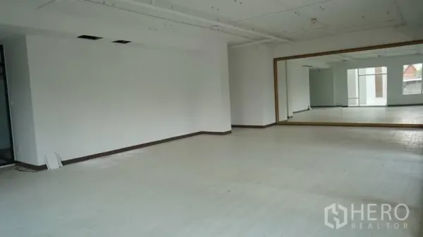 Retail Space for rent in Khlong Toei, Bangkok - Open-plan retail space featuring an oversized mirror, white floors and exposed ceiling for flexible layouts.