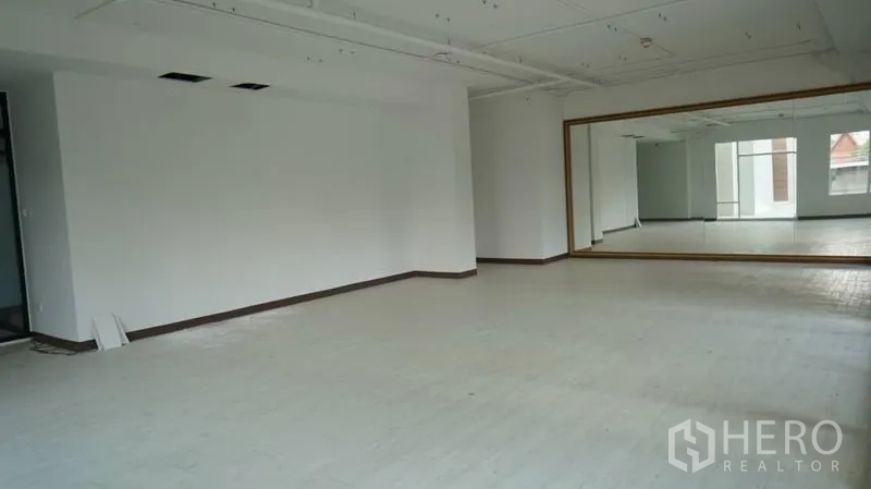 Retail Space for rent in Khlong Toei, Bangkok - Open-plan retail space featuring an oversized mirror, white floors and exposed ceiling for flexible layouts.