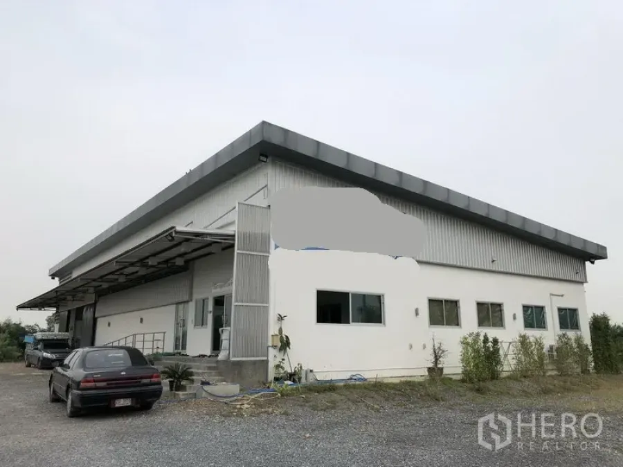 Factory for rent or sale in Wang Noi, Phra Nakhon Si Ayutthaya - Close view of modern metal-clad factory facade with wide roof eaves and windows.