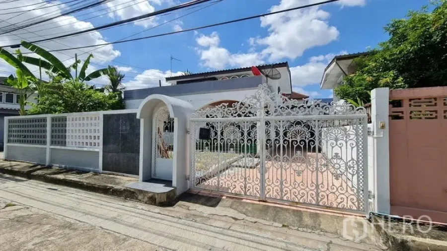 Detached House for rent in Lat Phrao, Bangkok - Ornate white wrought-iron front gate and boundary wall on a quiet lane.