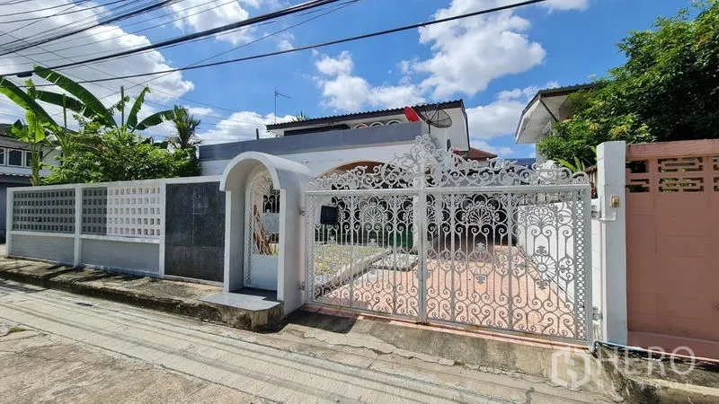 Detached House for rent in Lat Phrao, Bangkok - Ornate white wrought-iron front gate and boundary wall on a quiet lane.