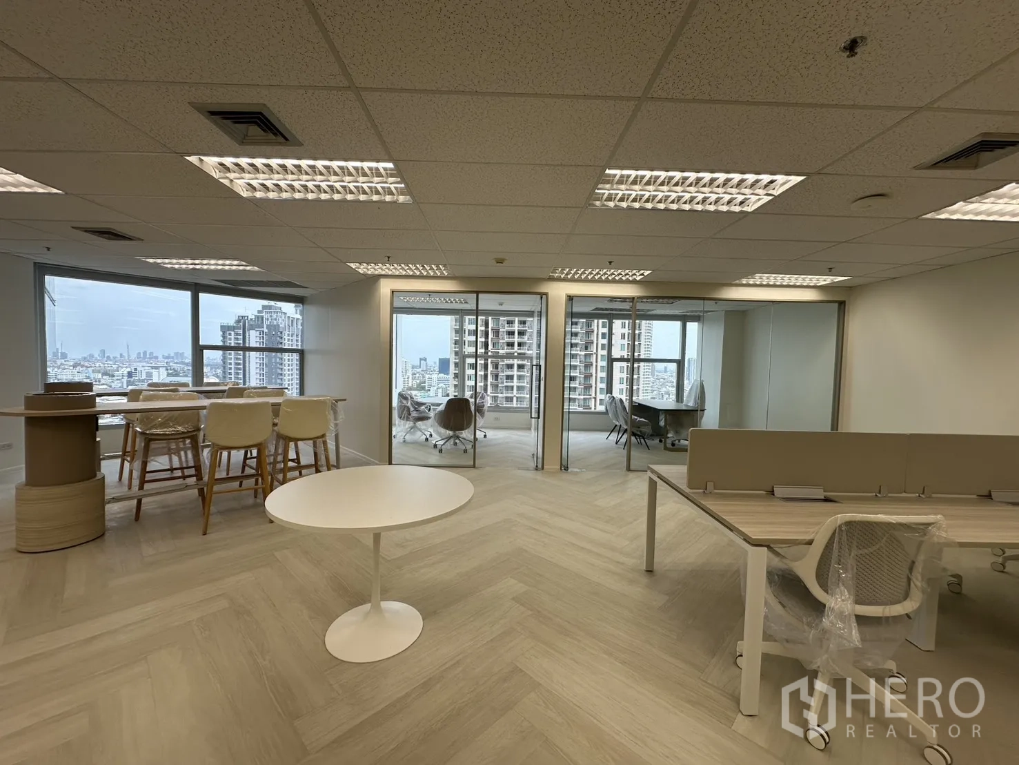 办公室 for rent in Sathon, Bangkok - 开放式区域可见玻璃会议室、吧台区与工位，临近落地窗。
