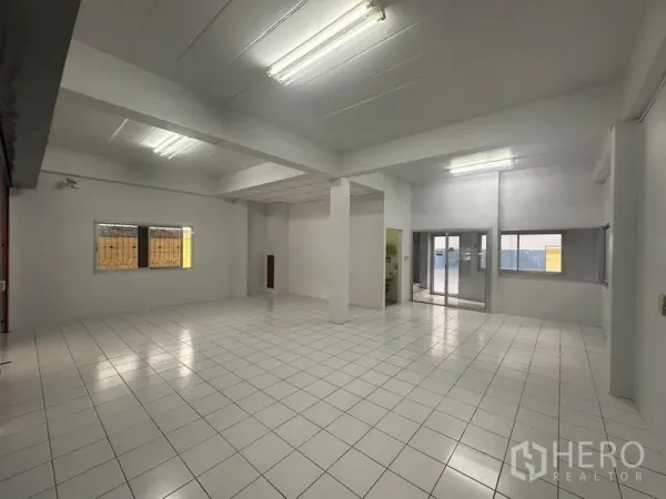 工厂 出租在Pathum Thani - 开放式白色室内，天花灯与瓷砖地面。
