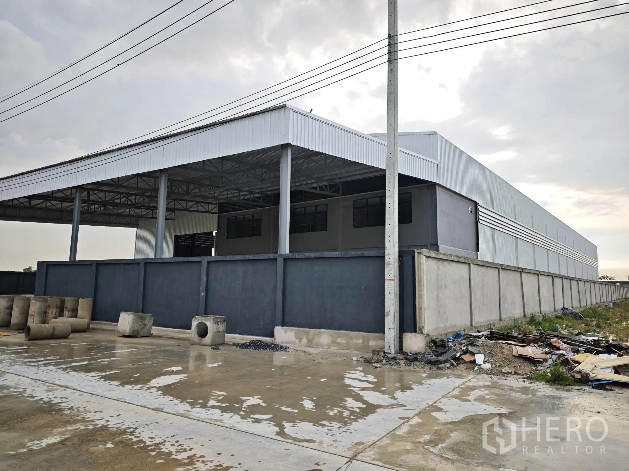 Warehouse for rent or sale in Bang Phli, Samut Prakan - Side exterior of the warehouse with perimeter wall and covered loading bay.