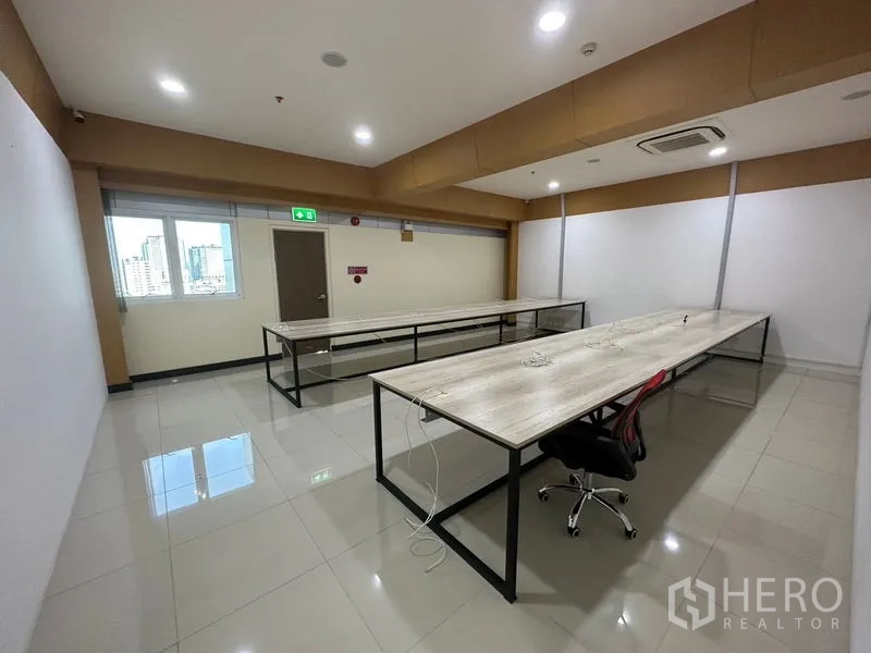 办公空间 出租在Suan Luang, Bangkok - 办公室内长工作台，带窗户与安全出口，自然采光充足。