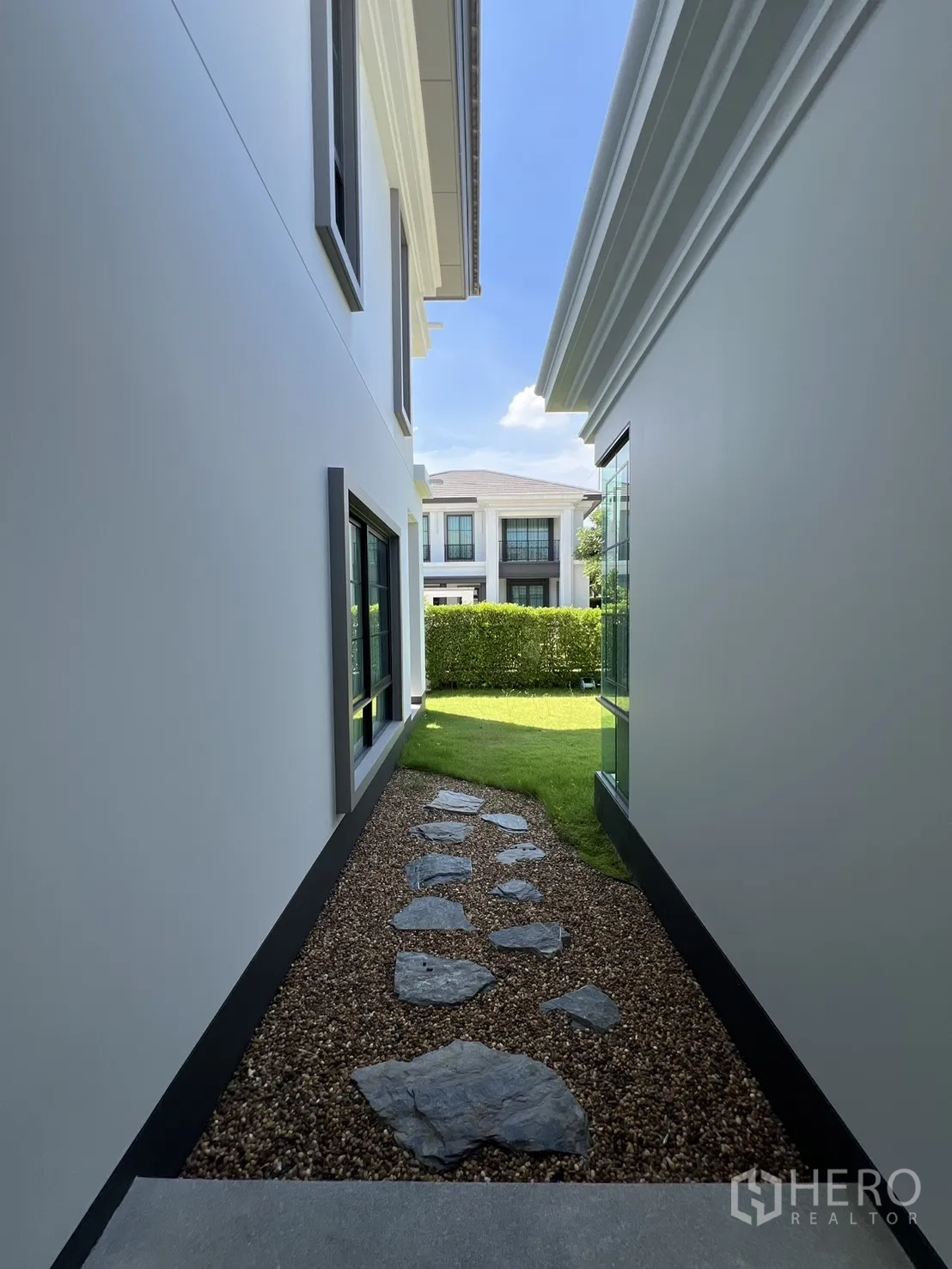 Detached House for rent or sale in Mueang Pathum Thani, Pathum Thani - Pebble pathway with stepping stones between buildings opening to the rear garden.