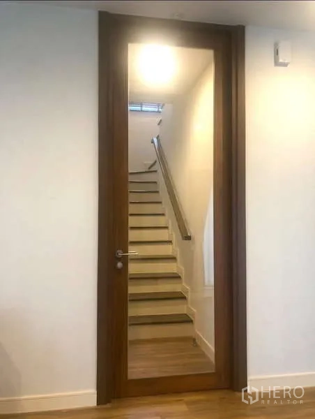Detached House for rent in Bang Kapi, Bangkok - Wood-framed glass door leading to a staircase with handrail.