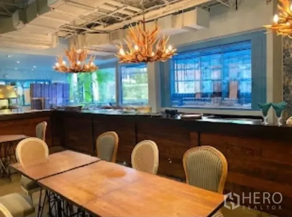 Retail Space for rent in Watthana, Bangkok - Close-up of bar counter with antler chandeliers and large windows.