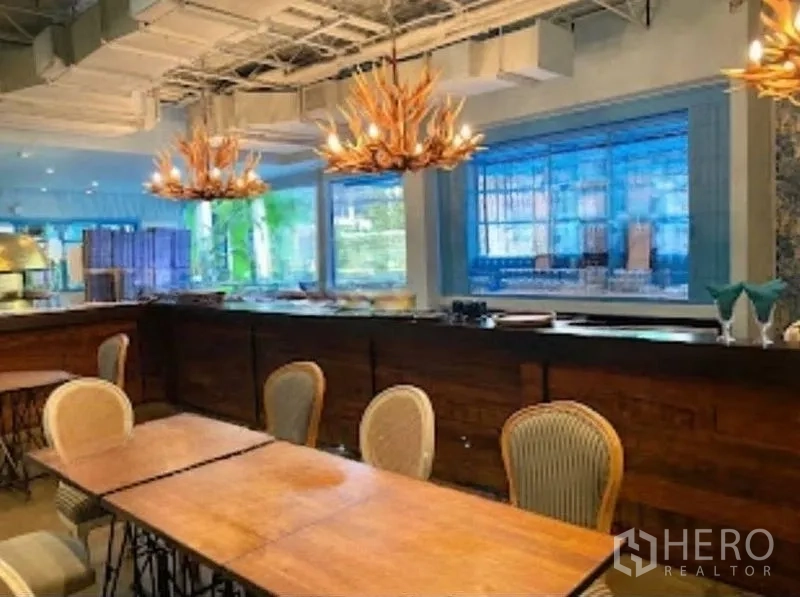 Retail Space for rent in Watthana, Bangkok - Close-up of bar counter with antler chandeliers and large windows.