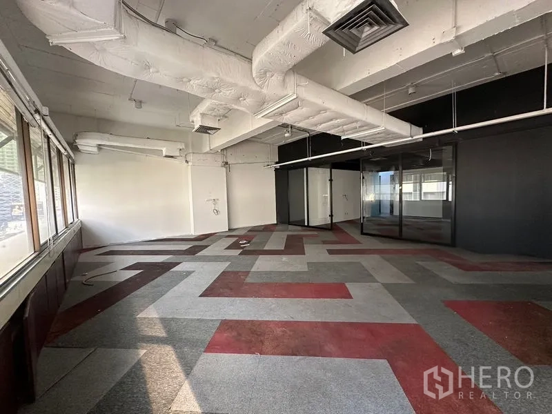 Office Space for rent in Watthana, Bangkok - Carpeted workspace with geometric pattern flooring, ducted ceiling, and glass-partitioned meeting rooms.